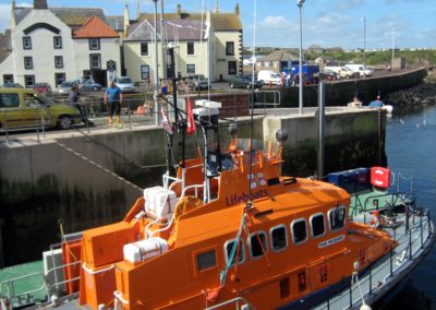 Eyemouth Lifeboat at its moorings with the Contented Sole in the background
