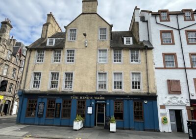 The King's Wark, Leith, Scotland - a large and ancient building shown in spring 2024 open as a pub, with stuccoed walls, a gabled roof, many white multi-paned windows, and a blue-painted ground floor.